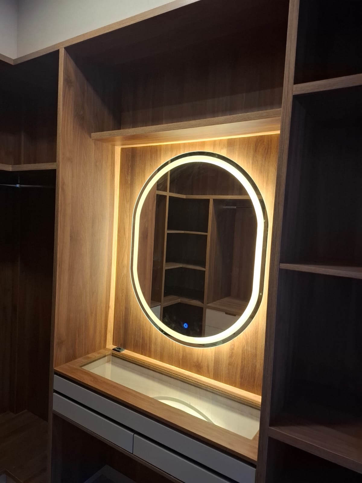 Closet planejado com penteadeira e espelho oval com iluminação em LED
