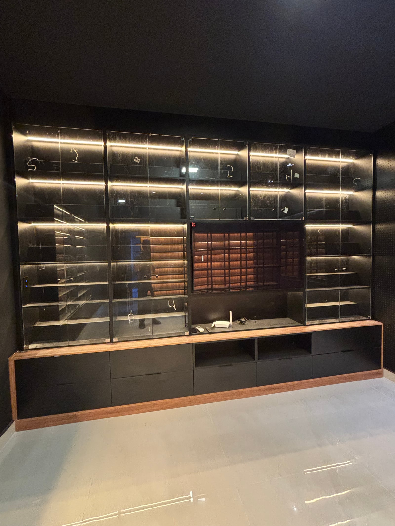 Painel de TV planejado com rack e armários de vidro iluminados
